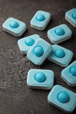 Siyah doku arka planında su yumuşatıcı haplar. Çamaşır makineleri ve bulaşık makineleri için kapsüller, kireçlenme ölçeğini engelliyor. Kopyalanacak yer.