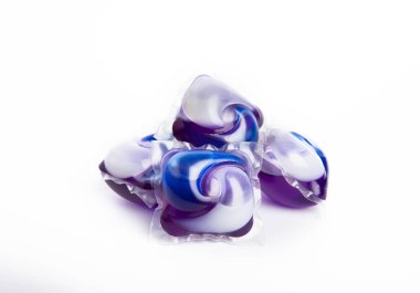 Çamaşır deterjanı yıkama kapsülleri çamaşır makinesinde çamaşır yıkamak için beyaz arka planda izole edilmiş. Saflık kavramı. Metin için yer.