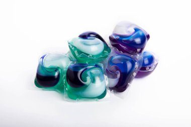 Çamaşır deterjanı yıkama kapsülleri çamaşır makinesinde çamaşır yıkamak için beyaz arka planda izole edilmiş. Saflık kavramı. Metin için yer.