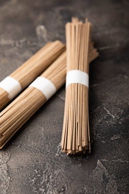 Siyah çimentoyla kaplanmış karabuğday ezmesi. Çiğ erişte. Glütensiz yemek için gerekli malzemeler. Kurutulmuş karabuğday sobalı erişte. Geleneksel Japon yemekleri. Sağlıklı yiyecekler. Kopyalanacak yer.