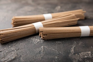 Siyah çimentoyla kaplanmış karabuğday ezmesi. Çiğ erişte. Glütensiz yemek için gerekli malzemeler. Kurutulmuş karabuğday sobalı erişte. Geleneksel Japon yemekleri. Sağlıklı yiyecekler. Kopyalanacak yer.