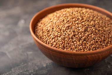 Siyah desenli mermer arka planda bir kasede karabuğday. Çiğ karabuğday. Glüten içermeyen mısır gevreği. Sağlıklı yiyecekler. Kopyalanacak yer.