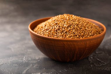 Siyah desenli mermer arka planda bir kasede karabuğday. Çiğ karabuğday. Glüten içermeyen mısır gevreği. Sağlıklı yiyecekler. Kopyalanacak yer.