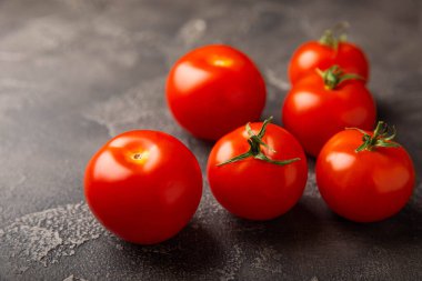 Siyah desenli mermer arka planda taze kırmızı domatesler. Yeşil saplı kiraz domatesleri. Taze sebzeler. Kopyalanacak yer. Organik gıda.