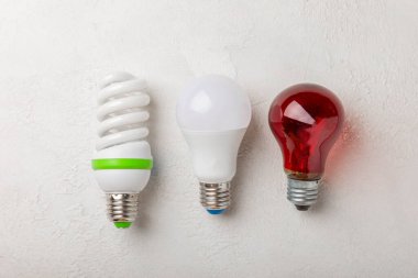 Elektrik ampulleri. Enerji verimliliği kavramı. LED lamba parlak lambaya karşı. Gri çimento arka planında kompozisyon. Ekonomik ve çevre dostu bir ampul kavramı kullan.