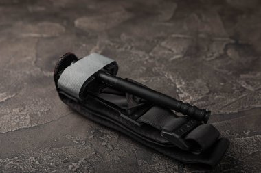 Siyah dokulu arka plandaki kanı durdurmak için tıbbi turnike. Kopyalanacak yer. düz yat.