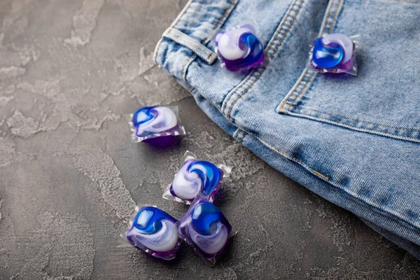 Siyah mermer arka planda mavi kotlu çamaşır kapsülleri. Çamaşır makinesinde çamaşır yıkamak için deterjan. Saflık kavramı. Metin için yer.