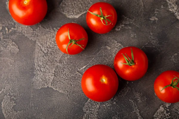 Siyah desenli mermer arka planda taze kırmızı domatesler. Yeşil saplı kiraz domatesleri. Taze sebzeler. Kopyalanacak yer. Organik gıda.