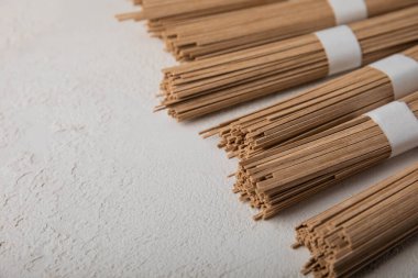 Arka planda gri çimento üzerine karabuğday ezmesi. Çiğ erişte. Glütensiz yemek için gerekli malzemeler. Kurutulmuş karabuğday sobalı erişte. Geleneksel Japon yemekleri. Sağlıklı yiyecekler. Kopyalanacak yer.