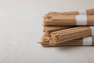 Arka planda gri çimento üzerine karabuğday ezmesi. Çiğ erişte. Glütensiz yemek için gerekli malzemeler. Kurutulmuş karabuğday sobalı erişte. Geleneksel Japon yemekleri. Sağlıklı yiyecekler. Kopyalanacak yer.