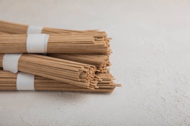 Arka planda gri çimento üzerine karabuğday ezmesi. Çiğ erişte. Glütensiz yemek için gerekli malzemeler. Kurutulmuş karabuğday sobalı erişte. Geleneksel Japon yemekleri. Sağlıklı yiyecekler. Kopyalanacak yer.