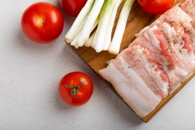 Domuz yağı, yeşil soğan, ev yapımı ekmek ve kiraz domatesli gri taşlı arka plan. Salo olsun. Lezzetli tuzlu domuz yağı ve biber. Kopya için yer var. Metin için boşluk.