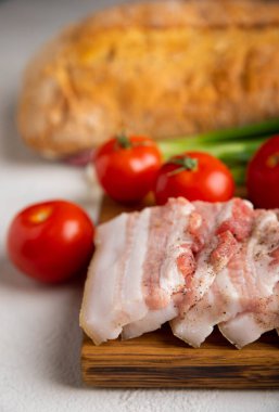 Domuz yağı, yeşil soğan, ev yapımı ekmek ve kiraz domatesli gri taşlı arka plan. Salo olsun. Lezzetli tuzlu domuz yağı ve biber. Kopya için yer var. Metin için boşluk.