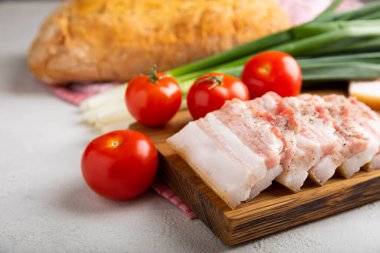 Domuz yağı, yeşil soğan, ev yapımı ekmek ve kiraz domatesli gri taşlı arka plan. Salo olsun. Lezzetli tuzlu domuz yağı ve biber. Kopya için yer var. Metin için boşluk.