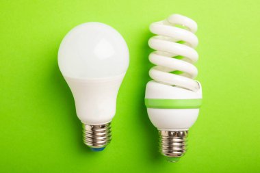 Elektrik ampulleri. Enerji verimliliği kavramı. LED lamba parlak lambaya karşı. Yeşil arka planda kompozisyon. Ekonomik ve çevre dostu bir ampul kavramı kullan.