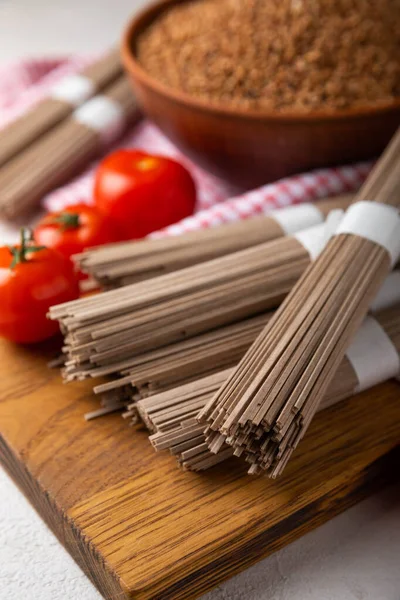 Siyah desenli mermer arka planda kiraz domatesli karabuğday makarnası. Çiğ makarna. Glütensiz yemek için gerekli malzemeler. Sağlıklı yiyecekler. Kopyalanacak yer.