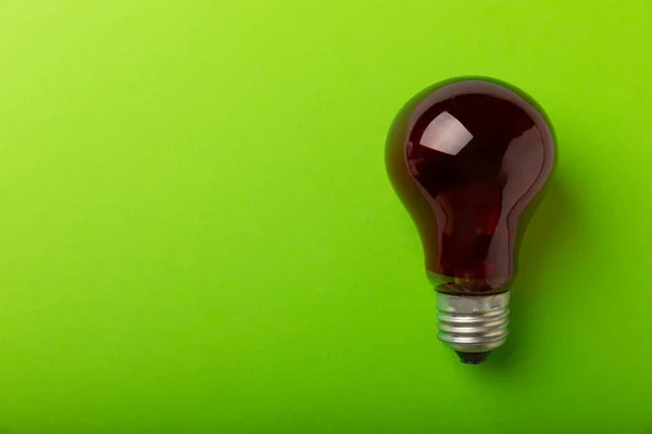 Red Light Bulb Close Green Paper Background Copy Space Space — Stock Photo, Image
