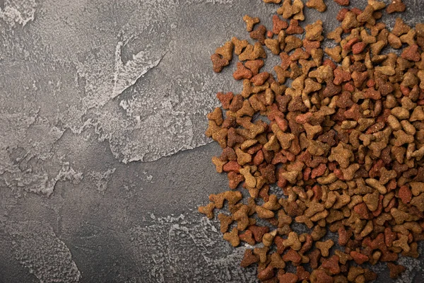 Dry food for cats on a cement background. Vitamins and nutrients for good health and energy of pets.Copy space.