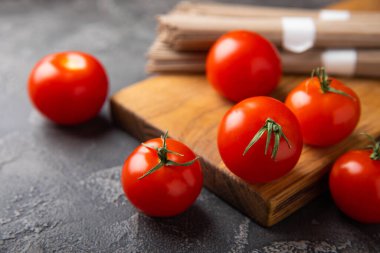 Siyah desenli mermer arka planda taze kırmızı domatesler. Yeşil saplı kiraz domatesleri. Taze sebzeler. Kopyalanacak yer. Organik gıda.