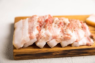 Gri taşlı arka planda domuz yağlı tahta. Salo olsun. Lezzetli tuzlu domuz yağı ve biber. Kopya için yer var. Metin için boşluk.