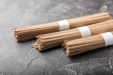 Siyah çimentoyla kaplanmış karabuğday ezmesi. Çiğ erişte. Glütensiz yemek için gerekli malzemeler. Kurutulmuş karabuğday sobalı erişte. Geleneksel Japon yemekleri. Sağlıklı yiyecekler. Kopyalanacak yer.