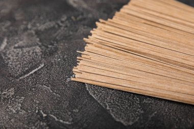 Siyah çimentoyla kaplanmış karabuğday ezmesi. Çiğ erişte. Glütensiz yemek için gerekli malzemeler. Kurutulmuş karabuğday sobalı erişte. Geleneksel Japon yemekleri. Sağlıklı yiyecekler. Kopyalanacak yer.