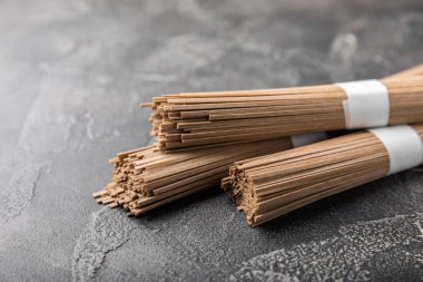 Siyah çimentoyla kaplanmış karabuğday ezmesi. Çiğ erişte. Glütensiz yemek için gerekli malzemeler. Kurutulmuş karabuğday sobalı erişte. Geleneksel Japon yemekleri. Sağlıklı yiyecekler. Kopyalanacak yer.