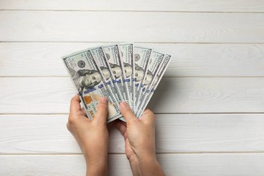 Para elinde. Beyaz dokuya sahip 100 dolarlık banknotlar. Para hesabı. Finans ve ekonomi kavramları. Para biriktirme konsepti. Para biriktiriyorum. Yatırımlar. Boşluğu kopyala.