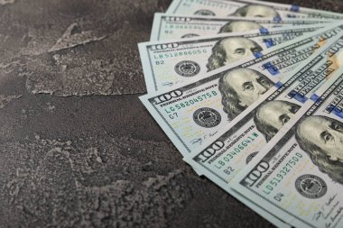Para, siyah çimento geçmişi üzerine 100 dolarlık banknotlar. Para masanın üzerine saçıldı. Finans ve ekonomi kavramları. Para biriktirme konsepti. Para biriktiriyorum. Yatırımlar. 