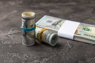 Para, siyah dokuya saçılmış banknotların arka planında 100 dolarlık banknotlar. Para masanın üzerine saçıldı. Finans ve ekonomi kavramları. Para biriktirme kavramı. 