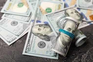 Para, siyah dokuya saçılmış banknotların arka planında 100 dolarlık banknotlar. Para masanın üzerine saçıldı. Finans ve ekonomi kavramları. Para biriktirme kavramı. 
