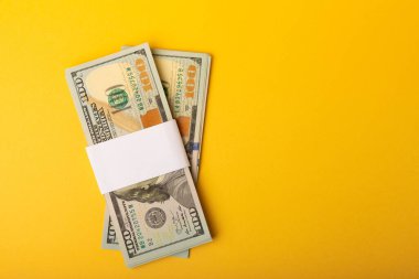 Para, sarı arka plandaki 100 dolarlık banknotlar. Para masanın üzerine saçıldı. Finans ve ekonomi kavramları. Para biriktirme konsepti. Para biriktiriyorum. Yatırımlar. 