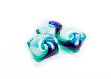 Çamaşır deterjanı yıkama kapsülleri çamaşır makinesinde çamaşır yıkamak için beyaz arka planda izole edilmiş. Saflık kavramı. Metin için yer.