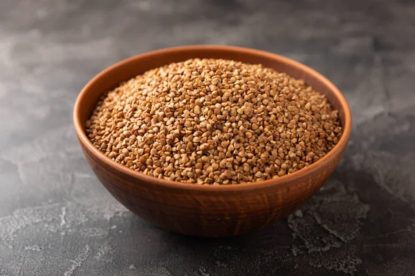 Siyah desenli mermer arka planda bir kasede karabuğday. Çiğ karabuğday. Glüten içermeyen mısır gevreği. Sağlıklı yiyecekler. Kopyalanacak yer.