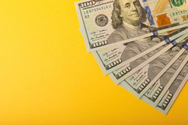 Para, sarı arka plandaki 100 dolarlık banknotlar. Para masanın üzerine saçıldı. Finans ve ekonomi kavramları. Para biriktirme konsepti. Para biriktiriyorum. Yatırımlar. 