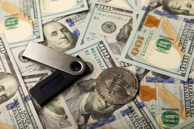 Kripto para birimi soğuk cüzdan ve 100 dolarlık banknotlar. İş konsepti. Para tasarrufu. Yatırım. Kripto para birimi. Bitcoin dijital para birimi. Kripto sikke para birimi depolama konsepti..