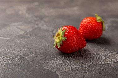 Siyah çimento masasında taze, sulu çilekler. Çilekli yaz kompozisyonu. Meyve konsepti. Vitamin. Eko meyveler. Boşluğu kopyala