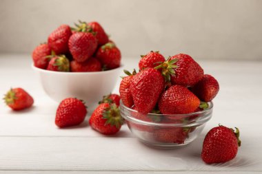 Taze olgun sulu çilekler beyaz tahta bir masada bir kasede. Çilekli yaz kompozisyonu. Meyve konsepti. Vitamin. Eko meyveler. Boşluğu kopyala