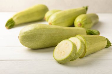 Beyaz ahşap bir masada taze organik kabak. Vejetaryen yemeği. Sağlıklı vejetaryen yemeği. Taze organik ürün. Sebze. Sağlıklı yiyecekler. Boşluğu kopyala.