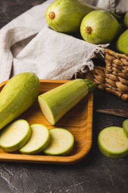 Taze organik kabak ve siyah ahşap bir masada dilimler. Vejetaryen yemeği. Sağlıklı vejetaryen yemeği. Taze organik ürün. Sebze. Sağlıklı yiyecekler. Boşluğu kopyala.