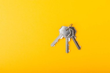 Evin anahtarları. Sarı arka planda kompozisyon. Tasarım elemanı. Emlak ve sigorta konsepti..