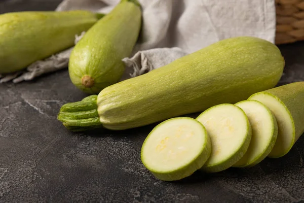 Taze organik kabak ve siyah ahşap bir masada dilimler. Vejetaryen yemeği. Sağlıklı vejetaryen yemeği. Taze organik ürün. Sebze. Sağlıklı yiyecekler. Boşluğu kopyala.