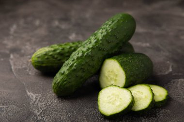 Taze organik salatalıklar ve ahşap dokuda dilimler. Salata için malzeme. Taze sebze. Sağlıklı yiyecek..