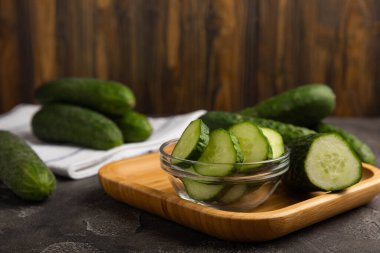 Taze organik salatalıklar ve ahşap dokuda dilimler. Salata için malzeme. Taze sebze. Sağlıklı yiyecek..