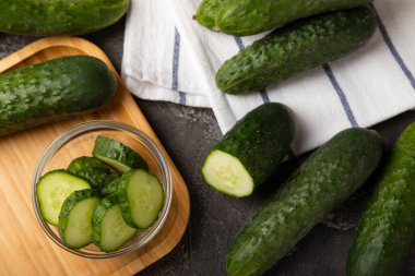 Taze organik salatalıklar ve ahşap dokuda dilimler. Salata için malzeme. Taze sebze. Sağlıklı yiyecek..