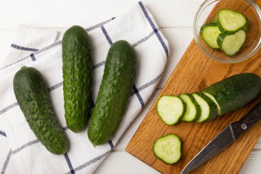 Taze organik salatalıklar ve ahşap dokuda dilimler. Salata için malzeme. Taze sebze. Sağlıklı yiyecek..