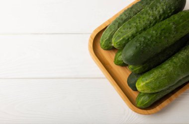 Taze organik salatalıklar ve ahşap dokuda dilimler. Salata için malzeme. Taze sebze. Sağlıklı yiyecek..