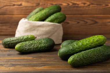 Taze organik salatalıklar ve ahşap dokuda dilimler. Salata için malzeme. Taze sebze. Sağlıklı yiyecek..