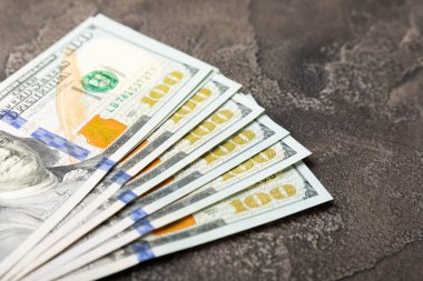 Para, siyah çimento geçmişi üzerine 100 dolarlık banknotlar. Para masanın üzerine saçıldı. Finans ve ekonomi kavramları. Para biriktirme konsepti. Para biriktiriyorum. Yatırımlar. 