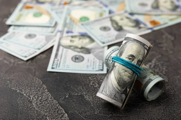 Para, siyah dokuya sahip yüz dolarlık banknotlar. Para masanın üzerine saçıldı. Finans ve ekonomi kavramları. Para biriktirme konsepti. Para biriktiriyorum. Yatırımlar.